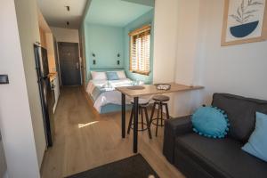a bedroom with a bed and a table and a couch at Ocean-Πολυτελές διαμέρισμα στο Αγρίνιο in Agrinio
