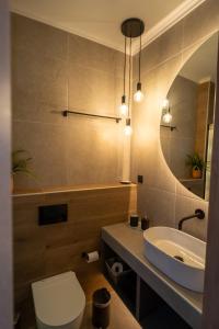 a bathroom with a sink and a toilet and a mirror at Ocean-Πολυτελές διαμέρισμα στο Αγρίνιο in Agrinion