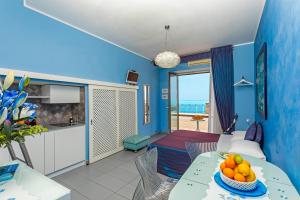 a living room with blue walls and a table with fruit on it at Casa Mare Sea View in Giardini Naxos