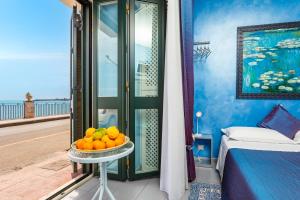 a bowl of oranges on a table next to a bed at Casa Mare Sea View in Giardini Naxos