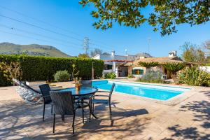 a patio with a table and chairs next to a pool at Villa Can Tonet in Port de Pollensa