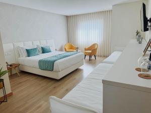a white bedroom with a bed and two chairs at Encosta do Monte - Charming Villa in Ponte de Lima +74 photos