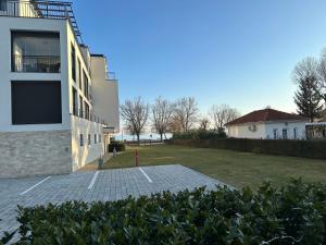 a house with a parking lot in front of it at Royal Apartman am See in Csopak