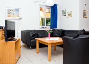 a living room with a couch and a table with a tv at Ferienwohnung Ferienhäuser am Brocken, 60 qm 2 Schlafzimmer in Ilsenburg