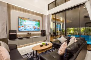 a living room with a couch and a table at Black Rocher Poolvilla Huahin in Hua Hin