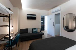 a room with a bed and a couch and a mirror at Tre Gemme in Centro - Suite Azure in Pescara