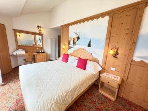 a bedroom with a bed and a window with a deer outside at Hotel Europa in San Martino di Castrozza +37 photos