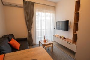 a hotel room with a bed and a television at Orange Luxury apartment in agrinio in Agrinio