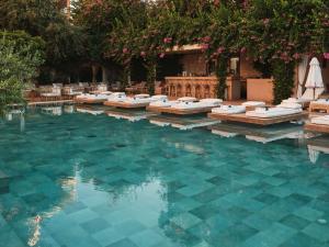 a swimming pool with chaise lounges in the water at The Margi in Athens