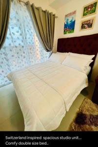 a bed with a white comforter in a bedroom at E4 Condotel CDO in Cagayan de Oro