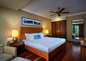 a bedroom with a large bed and a couch at The Taaras Beach & Spa Resort in Redang Island