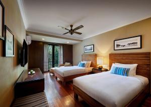 a hotel room with two beds and a ceiling fan at The Taaras Beach & Spa Resort in Redang Island