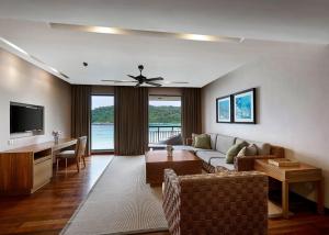 a living room with a couch and a table and a television at The Taaras Beach & Spa Resort in Redang Island