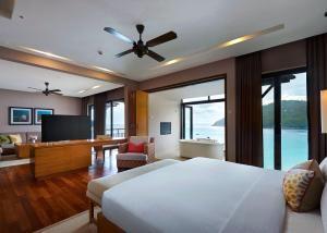 a bedroom with a bed and a television in a room at The Taaras Beach & Spa Resort in Redang Island
