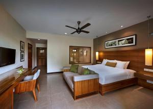 a bedroom with a large bed and a couch at The Taaras Beach & Spa Resort in Redang Island