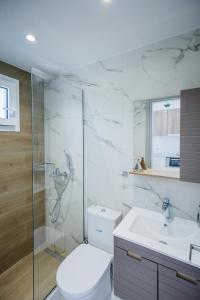a bathroom with a toilet and a shower and a sink at Sunny Sofi Studios in Plános
