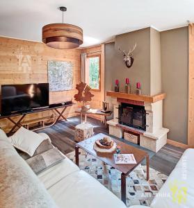 a living room with a couch and a fireplace at Chalet Les Mélèzes in Chambon-sur-Lac