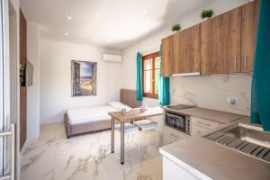 a kitchen with a table and a bed in a room at Sunny Sofi Studios in Planos