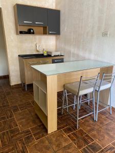 a kitchen with a counter and two chairs at a island at Sobrado inteligente com ótima localização in Foz do Iguaçu