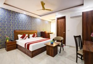 a bedroom with a bed and a desk in a room at Hotel The Venice- Near Indraprastha Apollo Hospital in New Delhi