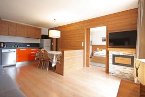 a kitchen and living room with a fireplace at Aurturist Valdaora Roulette in Valdaora