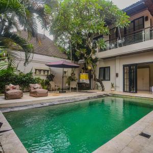 a swimming pool in front of a house at Villa EL Noya Umallas in Badung
