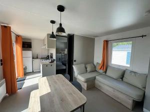 a living room with a couch and a table at Camping L'Orée des Caps in Licques