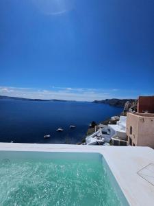 a swimming pool with a view of the ocean at Phaos Oia Suites in Oia