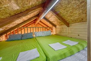 KalにあるEnchanted Cosy Chalet Kalanka - Happy Rentalsの屋根裏部屋の緑色のベッド +29枚の写真