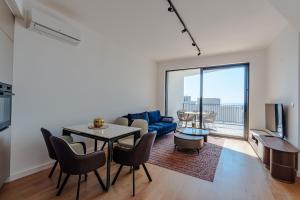 un soggiorno con un tavolo e un divano blu di Sunshine Appartement Budva a Bečići