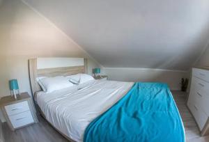 a bedroom with a large bed with a blue blanket at Charming House with Shared Pool in Atalaia, 110 m² in Lourinhã