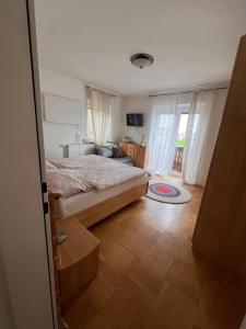 Un dormitorio con una cama y un sofá y ventanas. en Winzerhäuschen Kern, en Fehring