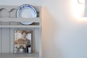 a plate on a shelf with a picture of a man at Casa CharmaRt in Asti