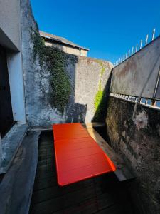 un banco rojo sentado al lado de un edificio en La Belle Tuffière, en Montreuil-Bellay