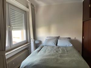 un letto con due cuscini in una camera da letto con finestra di 暖暖屋 a Mamer
