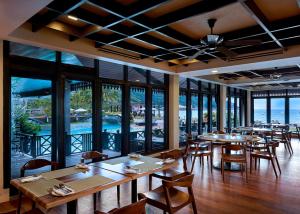 a restaurant with tables and chairs and a view of the ocean at The Taaras Beach & Spa Resort in Redang Island