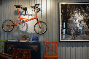 an orange bike is hanging on a wall at Nandha Hotel in Bangkok