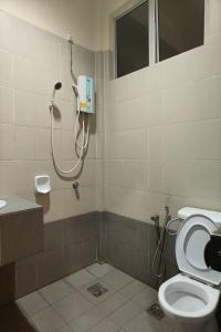 a bathroom with a toilet and a phone on the wall at Terengganu Equestrian Resort in Kuala Terengganu