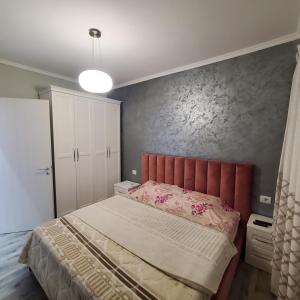 a bedroom with a large bed with a red headboard at Urban Charm Lalzi in Draç