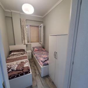 a small bedroom with two beds and a window at Urban Charm Lalzi in Draç