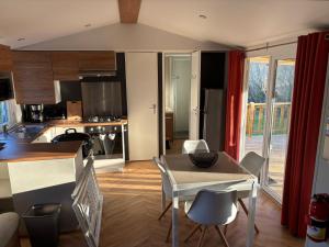 a kitchen and living room with a table and chairs at Mobil home camping kerlann 6 personnes 2 chambres emplacement idyllique in Pont-Aven