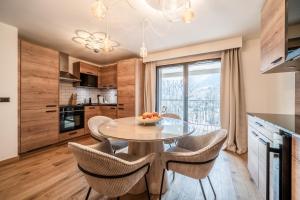 una cucina e una sala da pranzo con tavolo e sedie di Apartment Camox, Les Houches - by EMERALD STAY a Les Houches