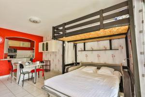 a bedroom with a bed and a kitchen with a table at Valentin - 50m plage - Parking in Plage-des-Demoiselles +5 photos