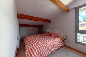a small bedroom with a bed and a window at Villa 13 - En duplex jardin privé à 400m du lac in Biscarrosse
