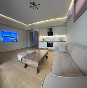 a living room with a couch and a table at Elysium residence Apartment in Nydri +3 photos