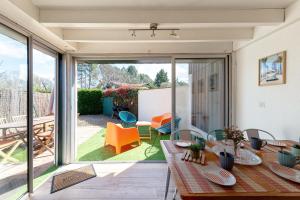 a dining room with a table and a sliding glass door at Villa 13 - En duplex jardin privé à 400m du lac in Biscarrosse