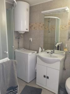 a white bathroom with a sink and a mirror at Holiday house with a parking space Drvenik , Drvenik - 24088 in Dolići