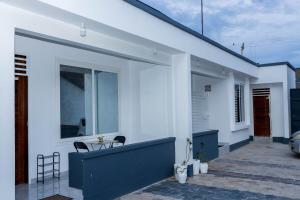 a white house with a table and chairs on a patio at Lily's Onebedroom Stylish Stay in Mbezi Beach in Dar es Salaam