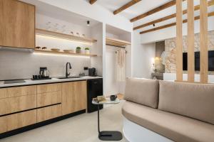 a living room with a couch and a kitchen at Onar -Quiet Luxury Suites with Private Jacuzzi-Ideal for Couples in Archangelos