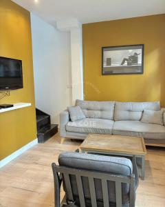 een woonkamer met een bank en een tafel bij Maison "Louisette" in Le Touquet-Paris-Plage